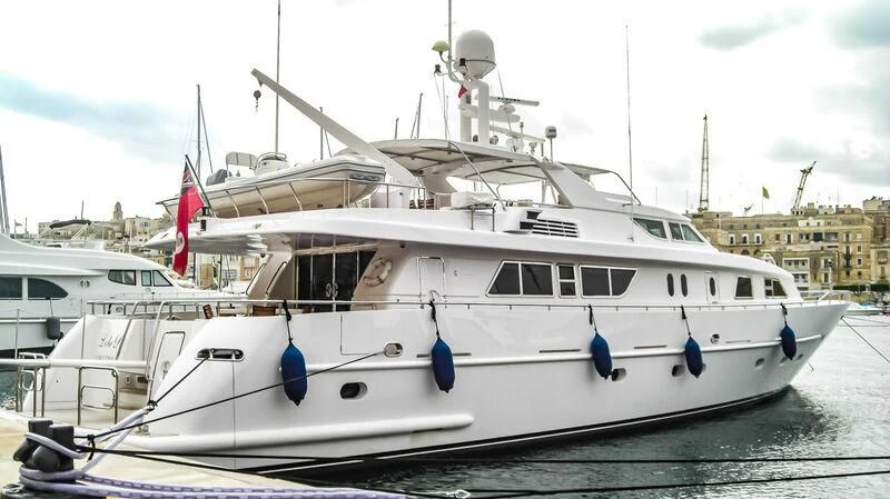 a white boat in a harbor aboard AMNA Yacht for Sale