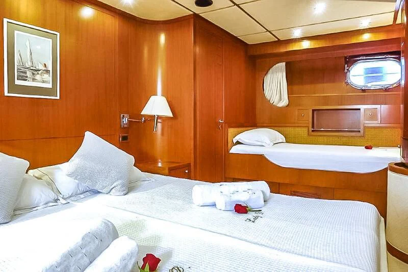 a room with a bed and a wood wall aboard AMNA Yacht for Sale