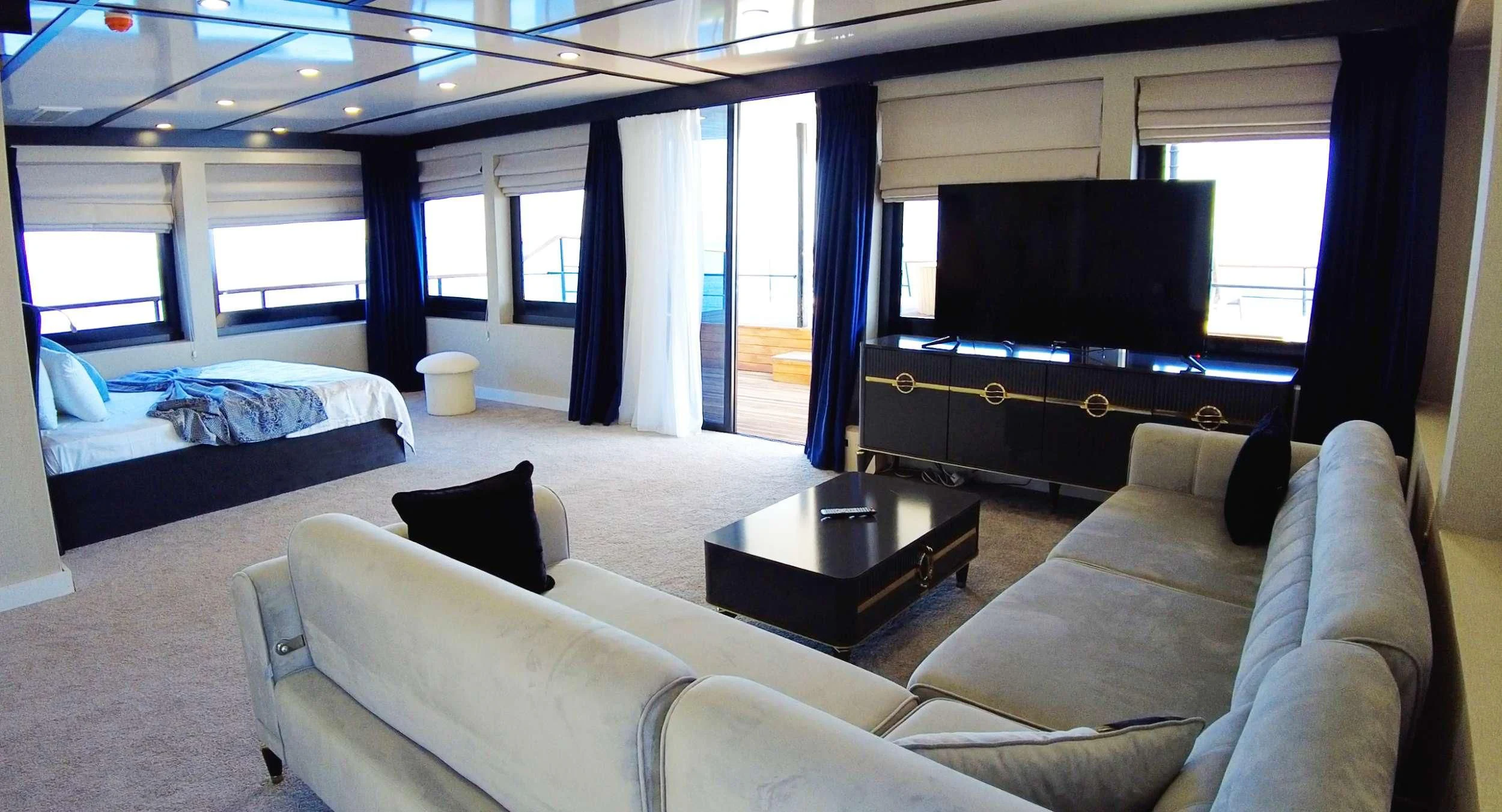 a room with a couch and a tv aboard LIMITLESS Yacht for Charter