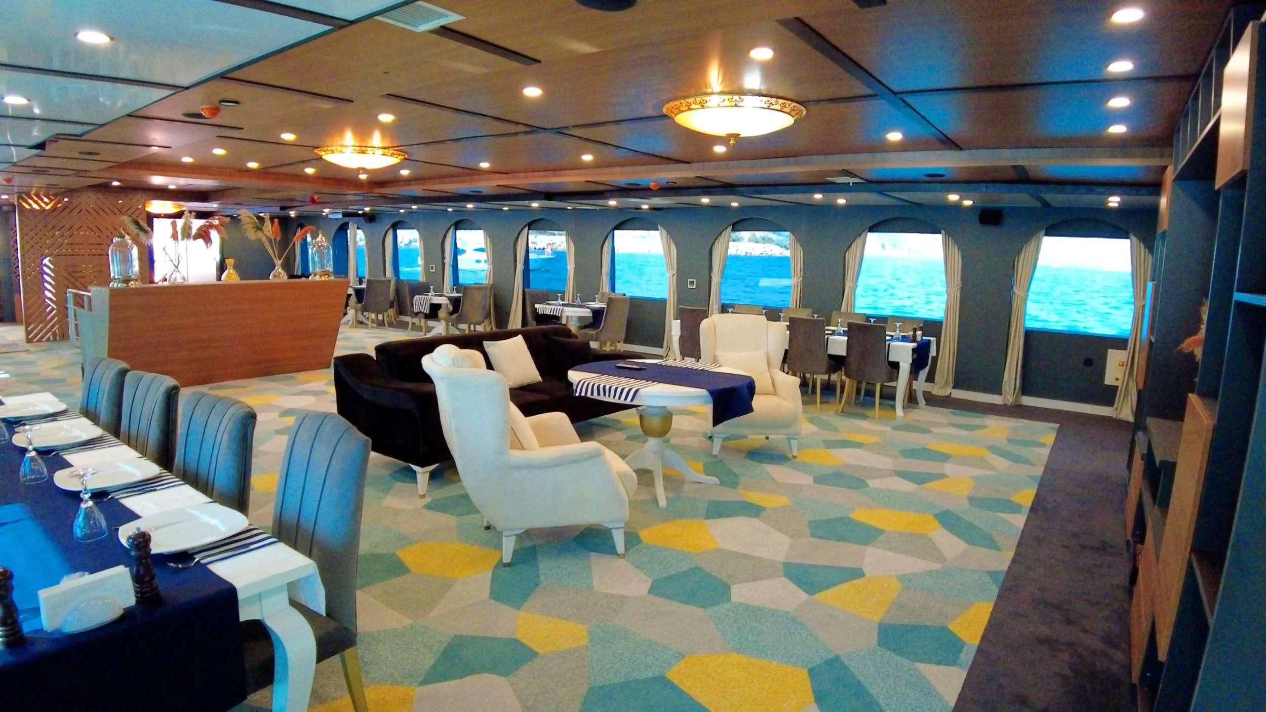 a room with tables and chairs aboard LIMITLESS Yacht for Charter