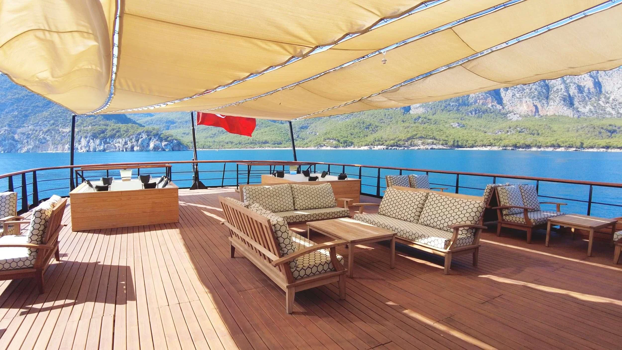 a deck with chairs and a table on it aboard LIMITLESS Yacht for Charter
