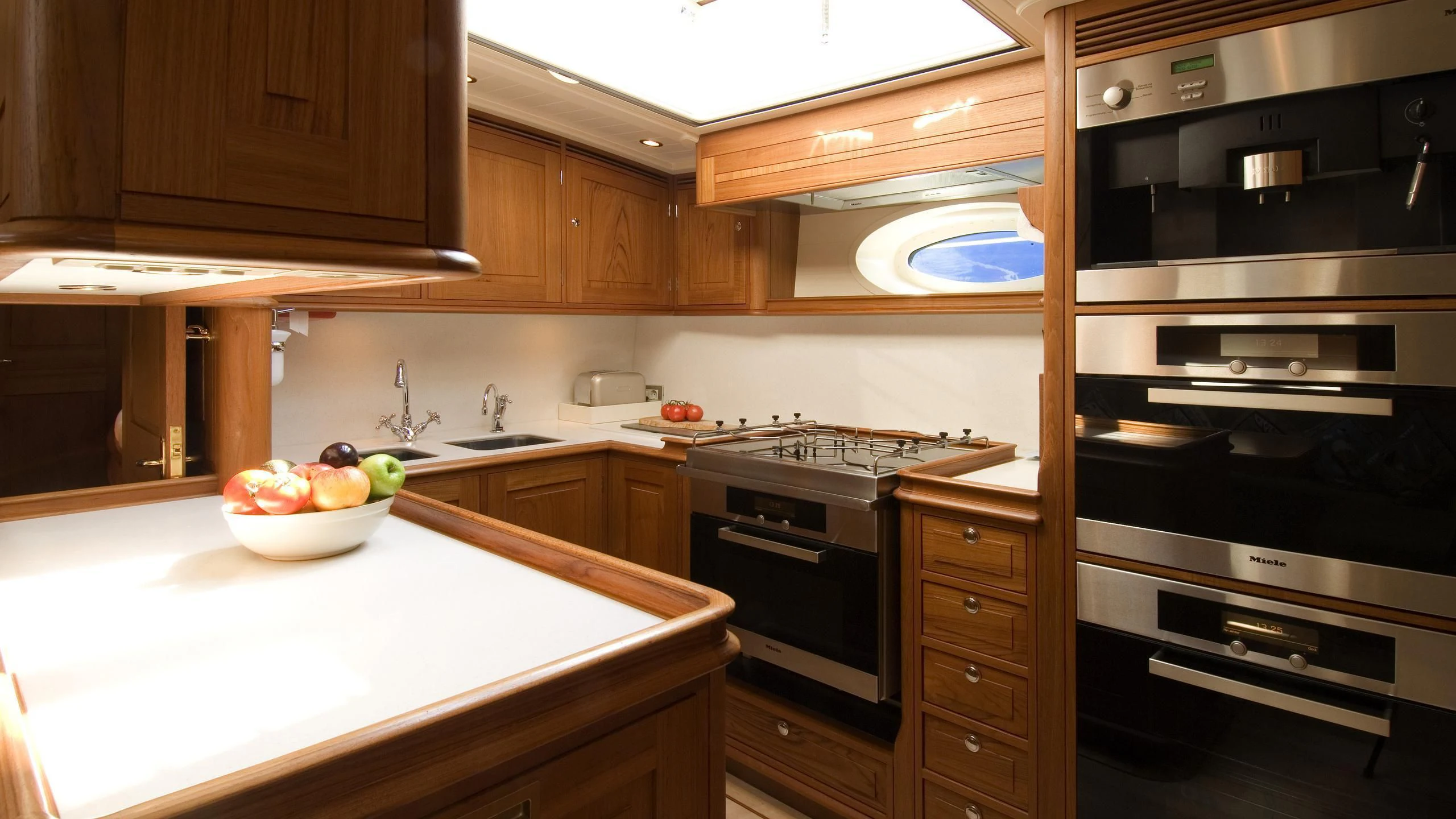 a kitchen with a bowl of fruit aboard VELACARINA Yacht for Sale