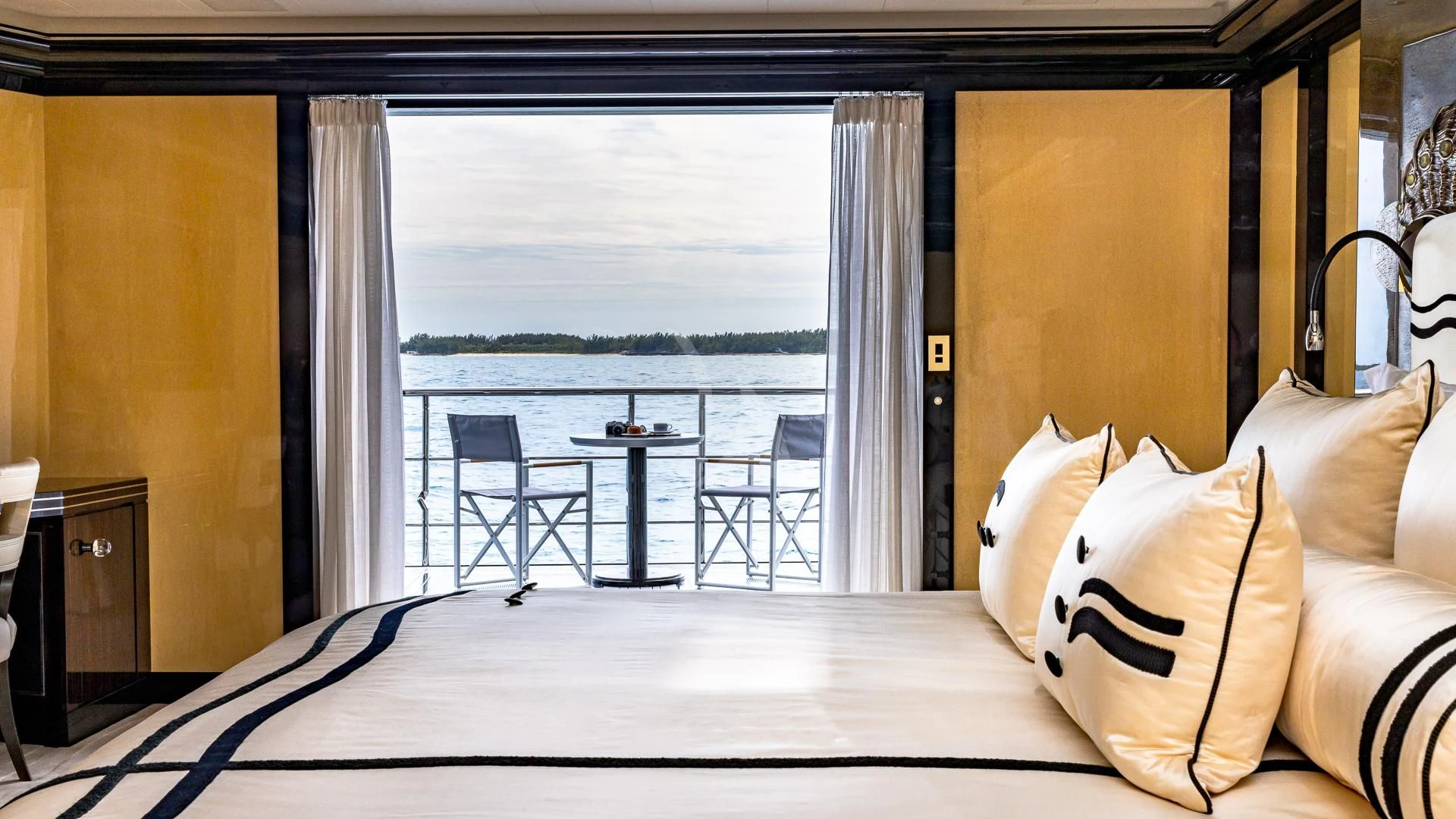 a bed with a table and chairs aboard OKTO Yacht for Charter
