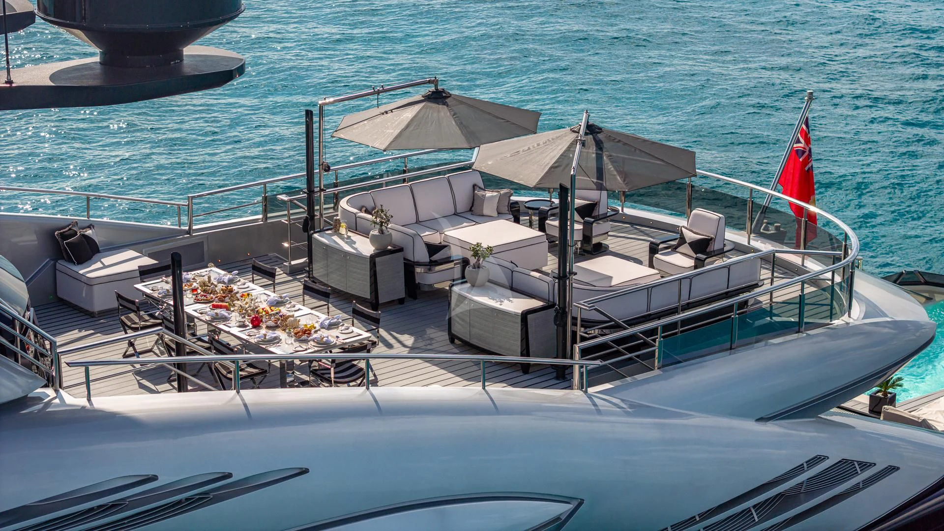a boat with a flag on the deck aboard OKTO Yacht for Charter