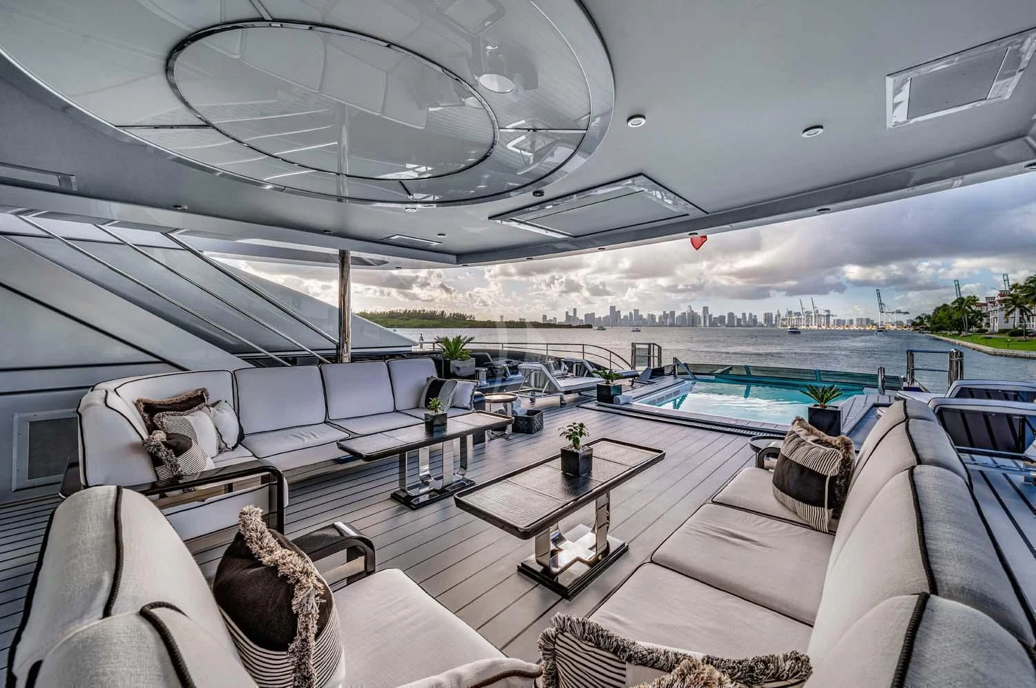 a lounge area with a pool and a deck with a large pool aboard OKTO Yacht for Charter