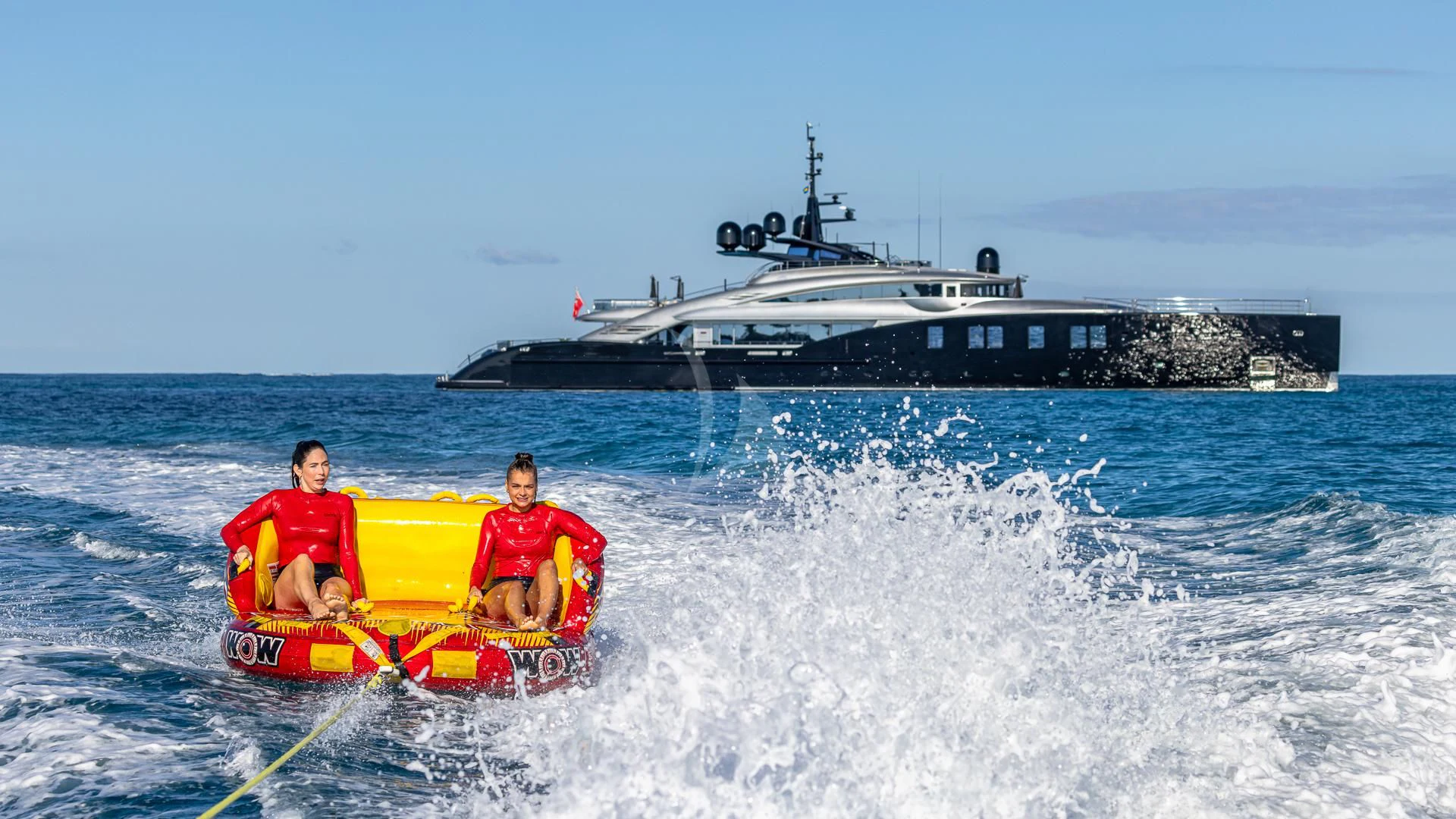 a man and a woman on a raft in the water aboard OKTO Yacht for Charter