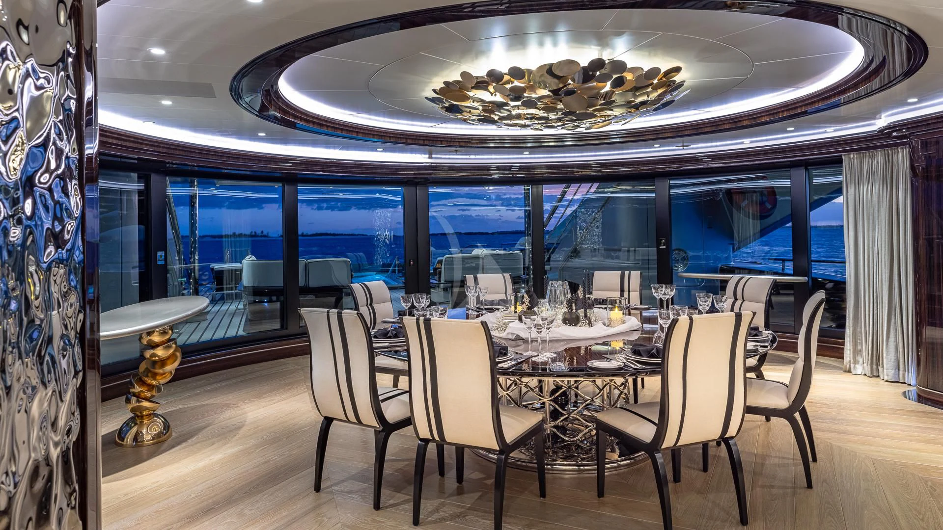 a dining room with a large chandelier aboard OKTO Yacht for Charter