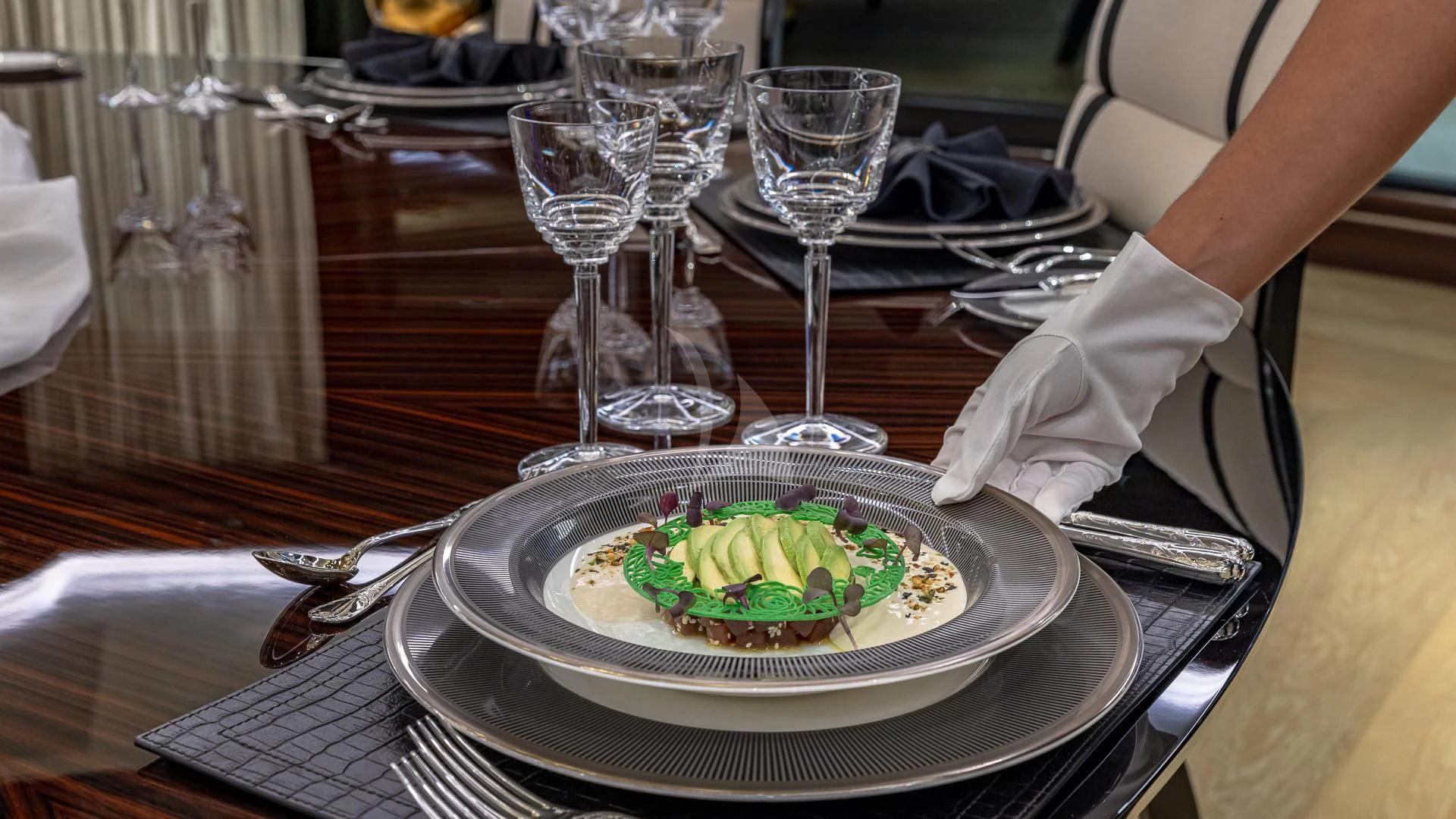 a plate of food and glasses aboard OKTO Yacht for Charter