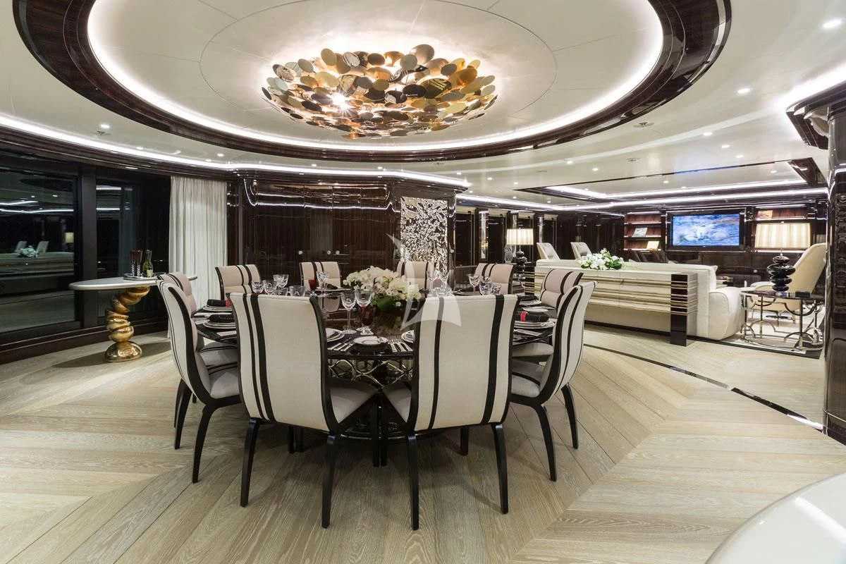 a large dining room with a chandelier aboard OKTO Yacht for Charter