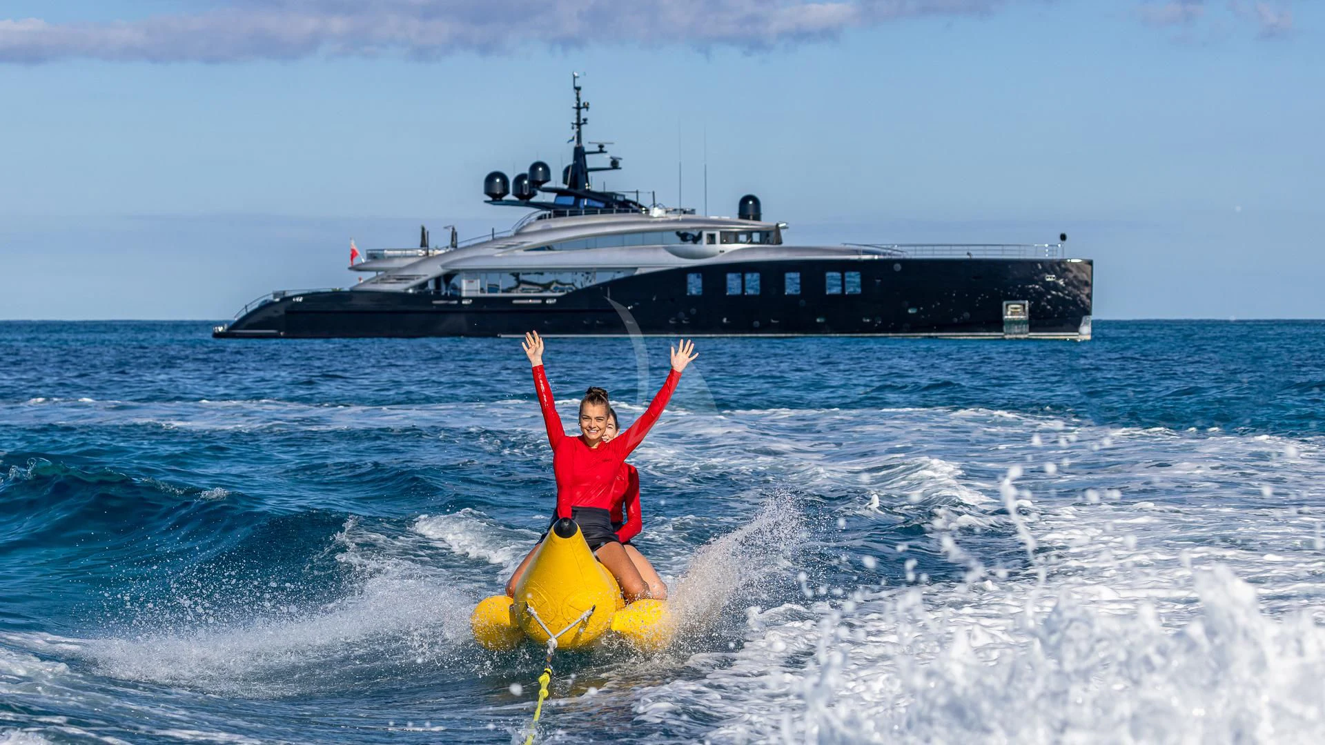 a person on a raft in the water with a boat in the background aboard OKTO Yacht for Charter