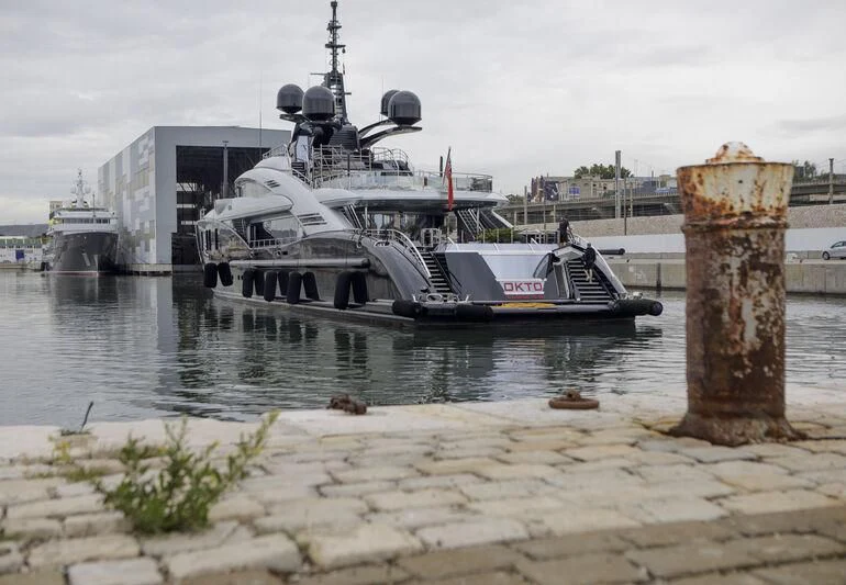 a large ship docked at a port aboard OKTO Yacht for Charter