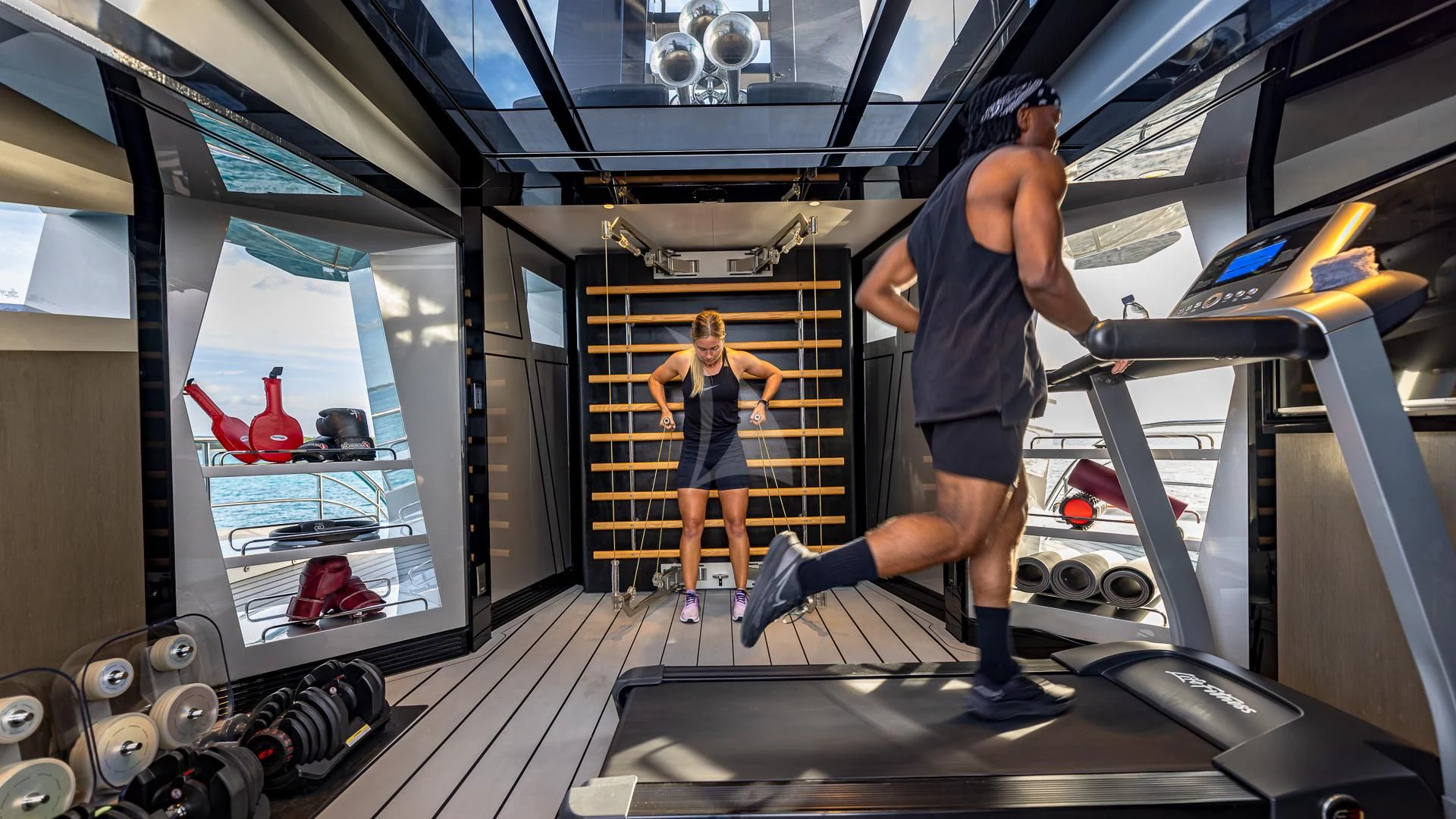 a man and a woman in a gym aboard OKTO Yacht for Charter