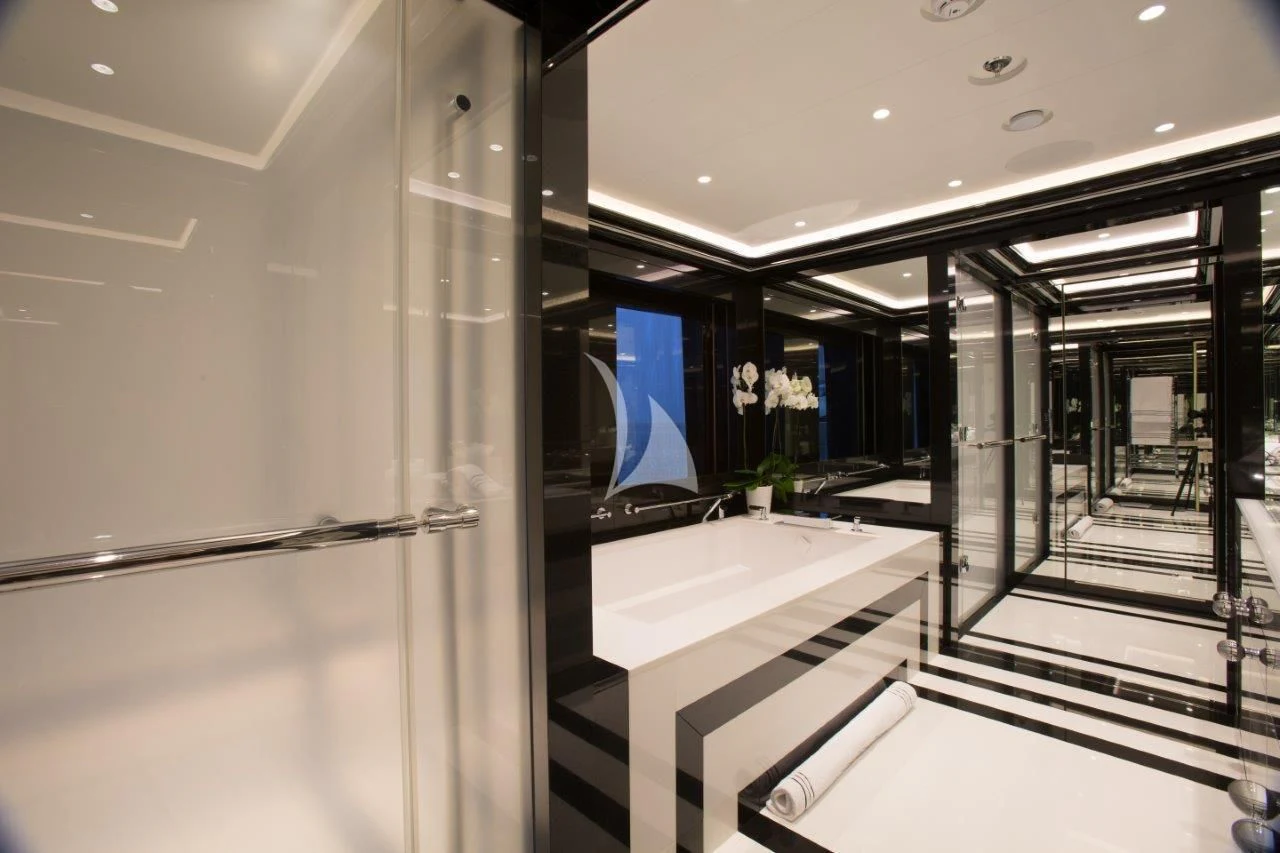 a room with a glass wall and a table with chairs and a window aboard OKTO Yacht for Charter