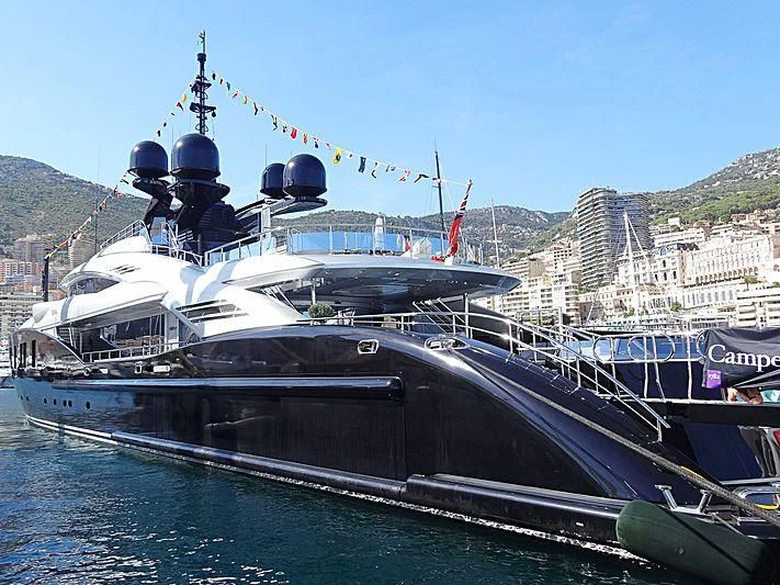 a large boat docked at a pier aboard OKTO Yacht for Charter