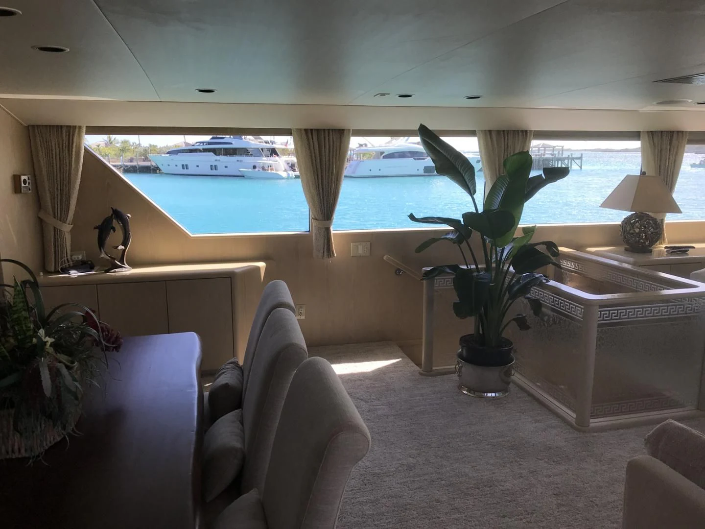a room with a plant and a table and chairs aboard MON SHERI Yacht for Sale