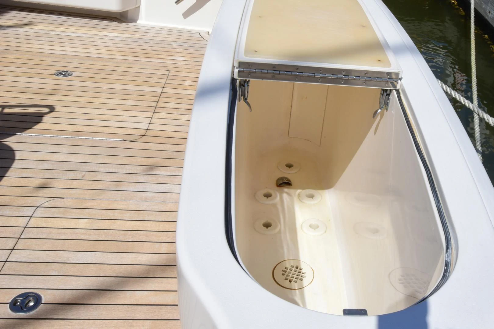 a white surfboard on a wooden deck aboard CRAZY J Yacht for Sale