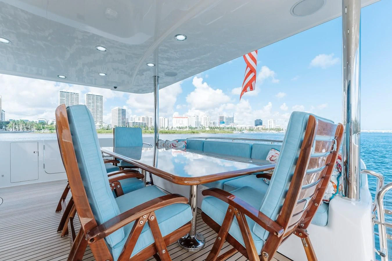 a deck with a table chairs and a flag on it aboard FINAL FINAL Yacht for Sale