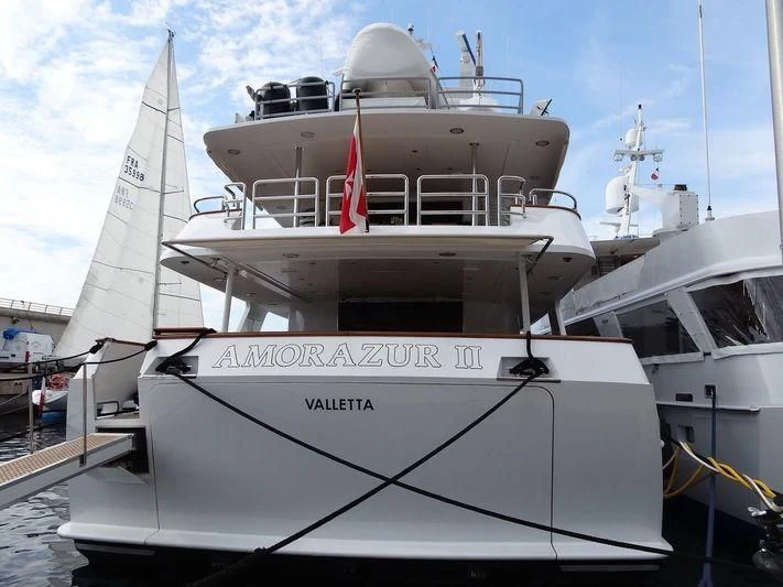 a white boat in a harbor aboard AMORAZUR II Yacht for Sale