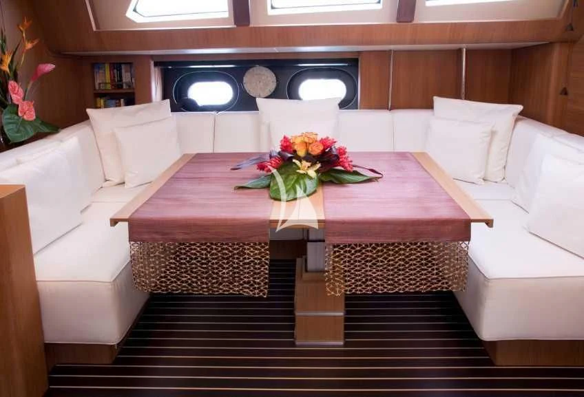 a room with a couch and a table with flowers on it aboard ICARUS Yacht for Sale