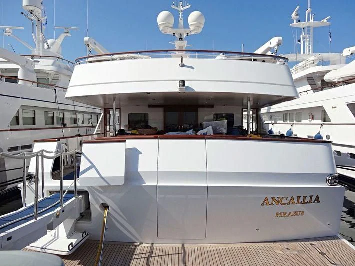 a large white boat with a white ship in the background aboard ANCALLIA Yacht for Sale