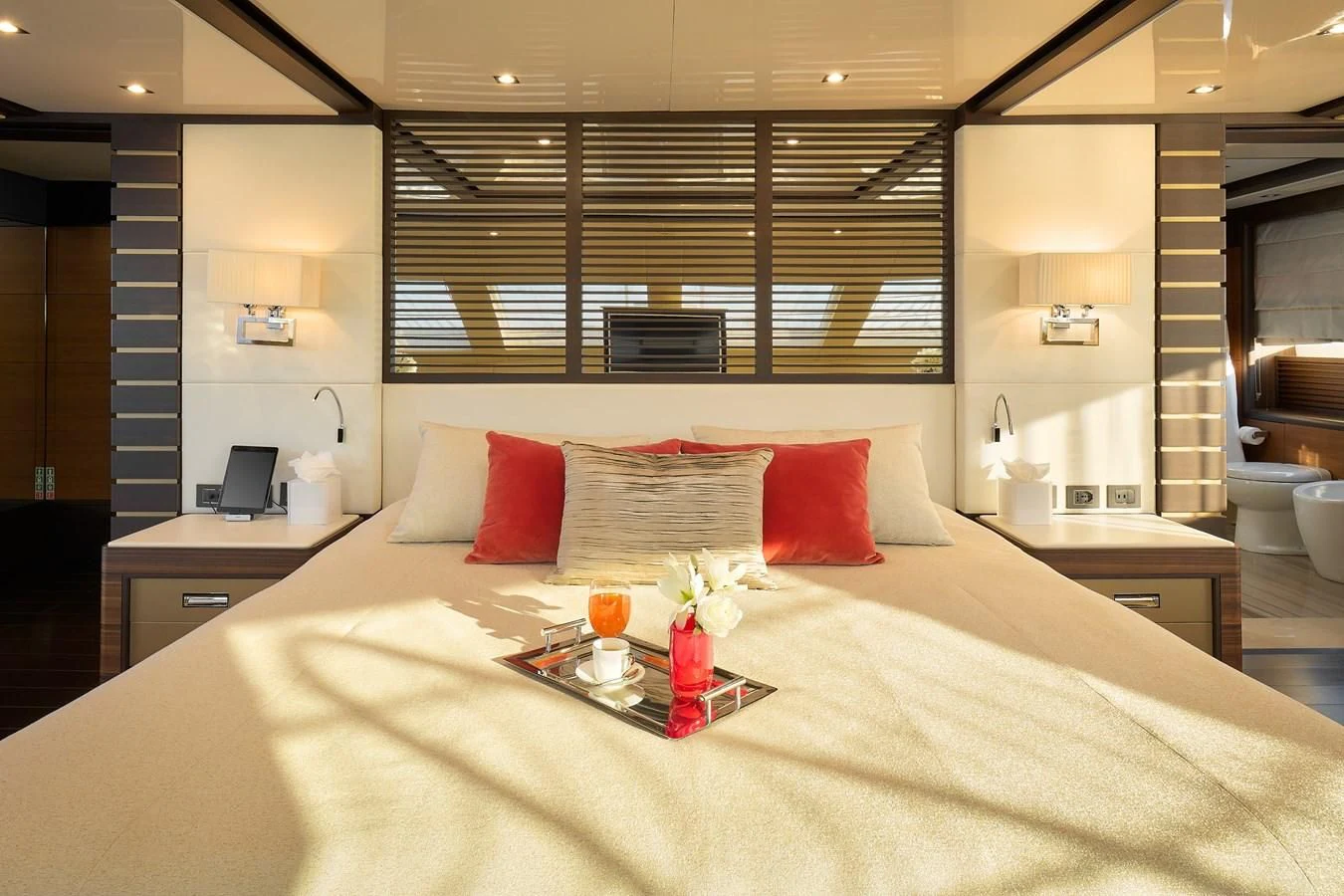 a bed with pillows and a tray of food on it aboard LADY MRD Yacht for Charter