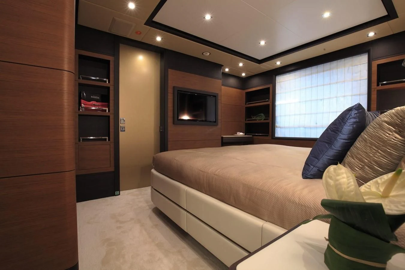 a room with a bed and a television aboard LADY MRD Yacht for Charter