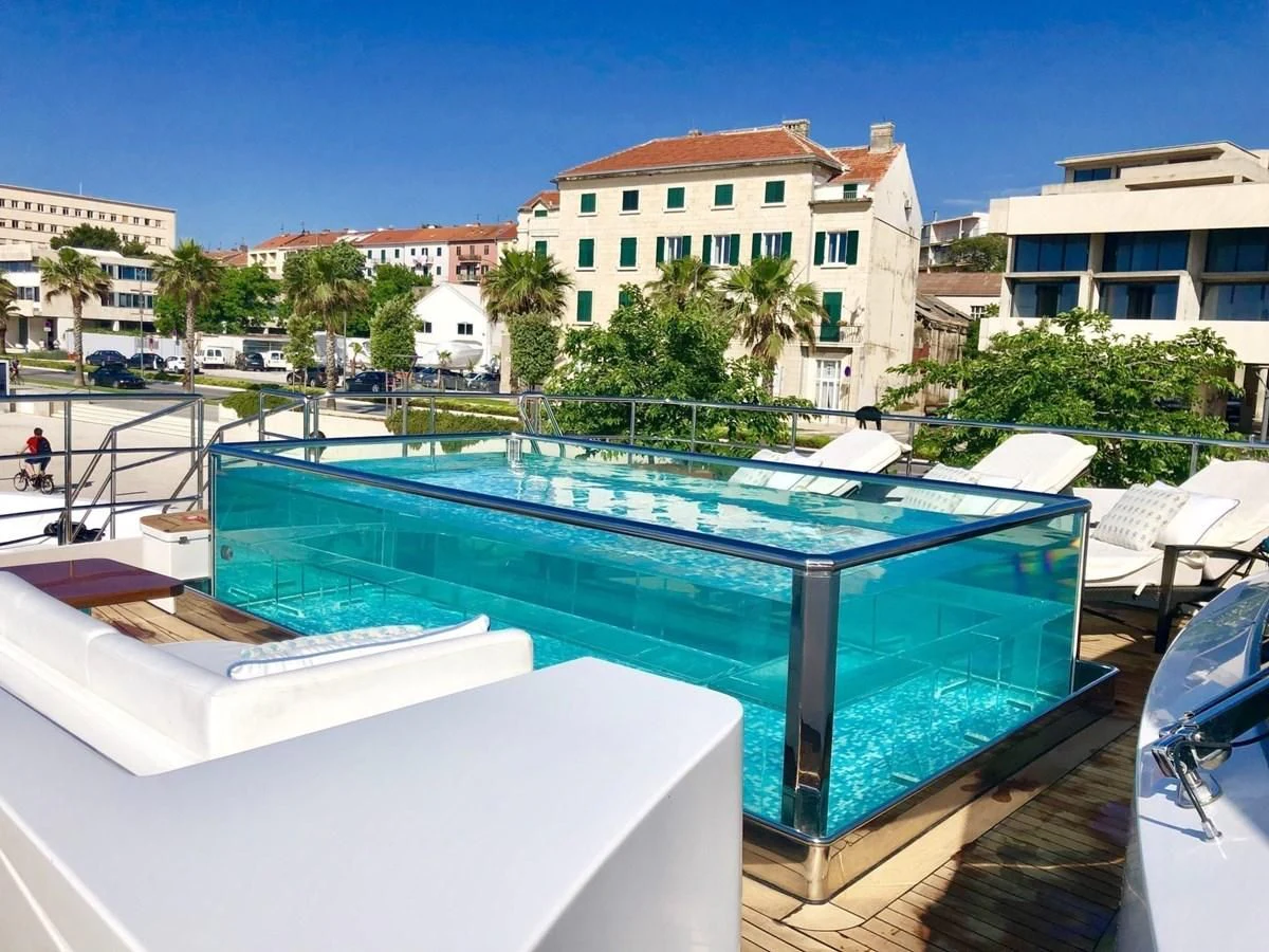 a pool with a building in the background aboard LADY MRD Yacht for Charter