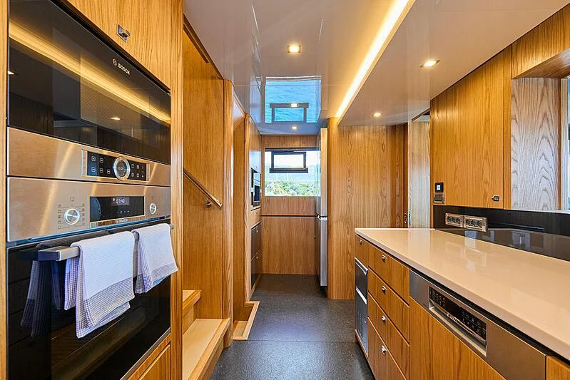 a kitchen with wooden cabinets aboard VERONIKA Yacht for Sale