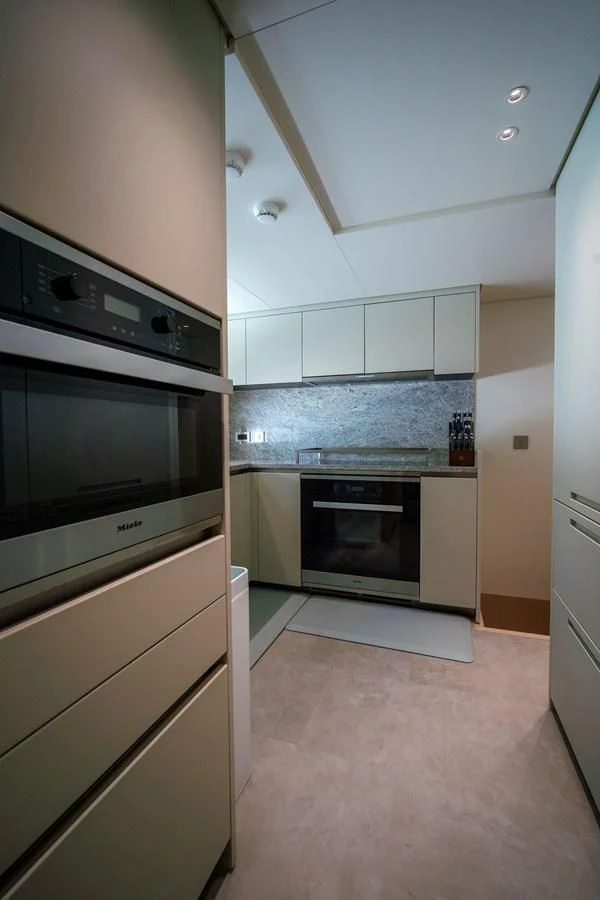 a kitchen with white cabinets aboard PEARL Yacht for Sale