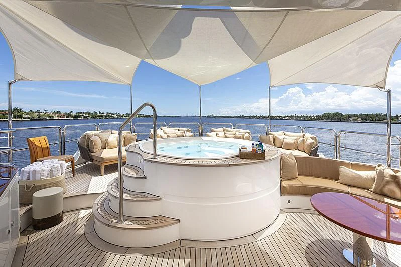 a large white lounge chair next to a large white bed on a boat aboard GROOVER Yacht for Sale