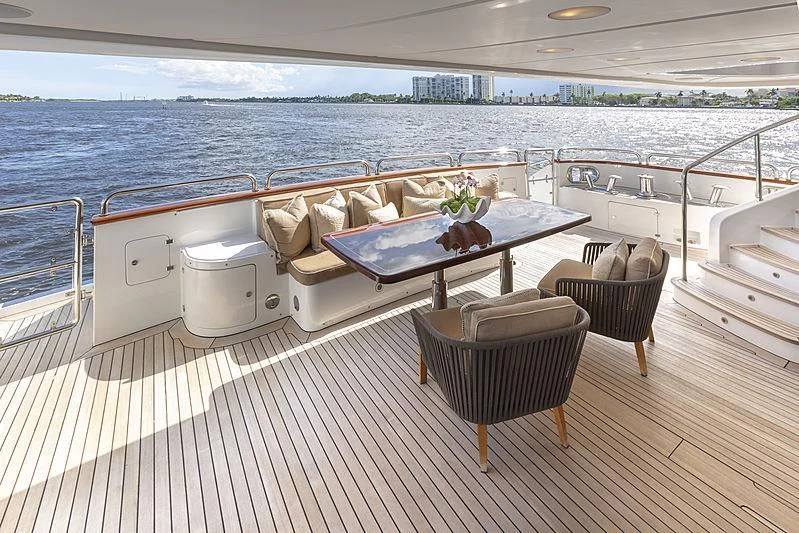 a deck with a table and chairs on it aboard GROOVER Yacht for Sale