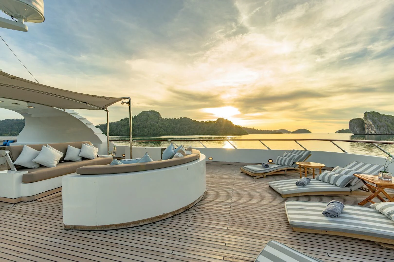 a deck with a view of a sunset and a body of water aboard AZUL V Yacht for Charter