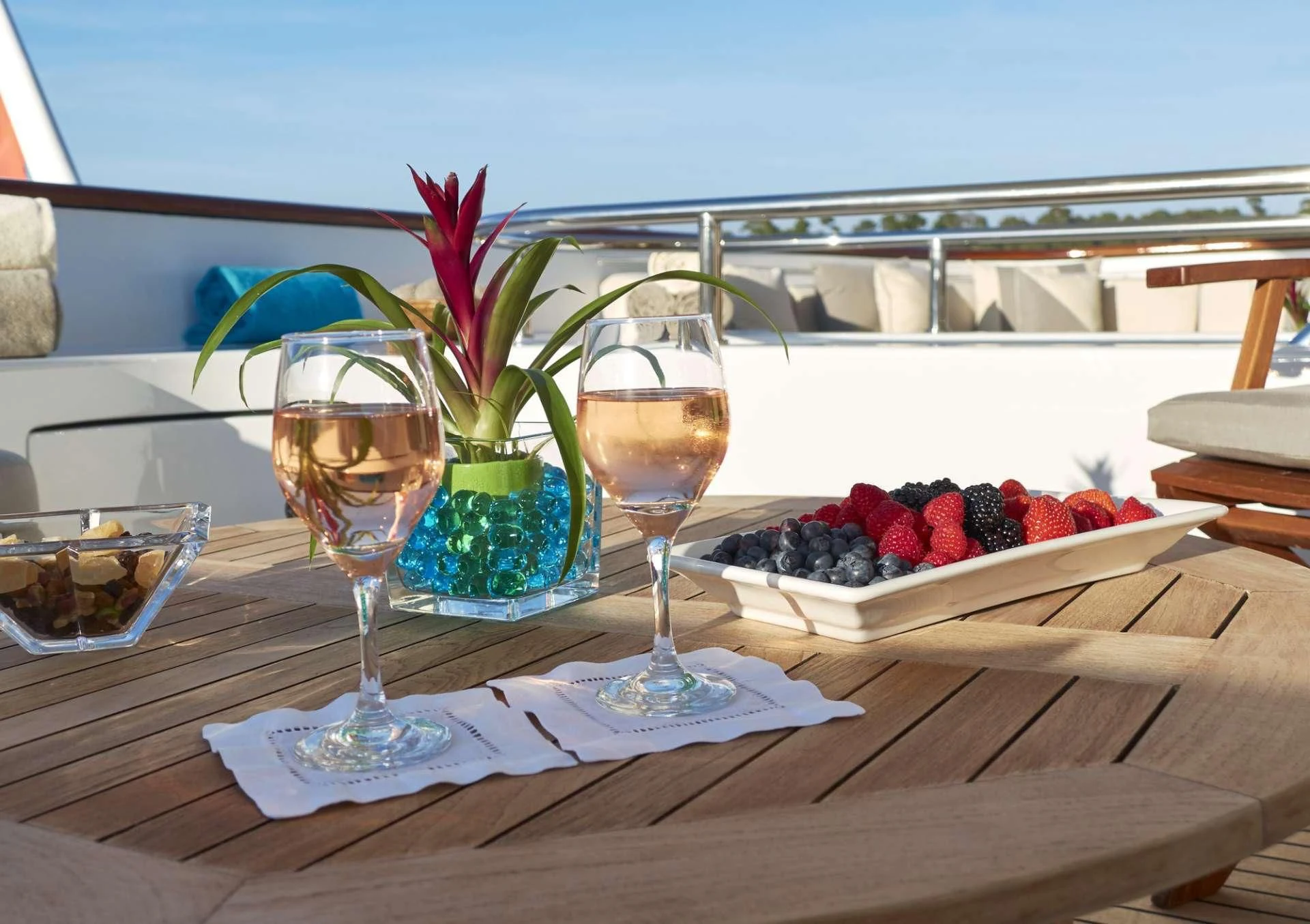 a couple of glasses with wine and fruit on a table aboard AZUL V Yacht for Charter