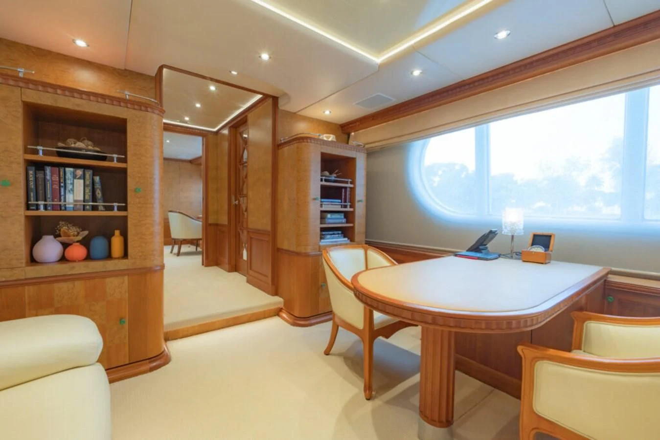 a dining table and chairs in a room with a window aboard AZUL V Yacht for Charter