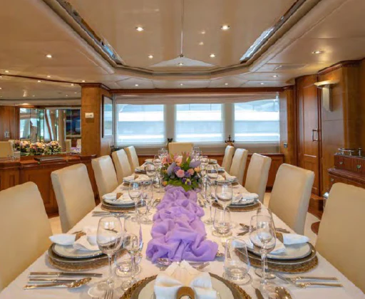 a dining room with a table set for a formal dinner aboard AZUL V Yacht for Charter