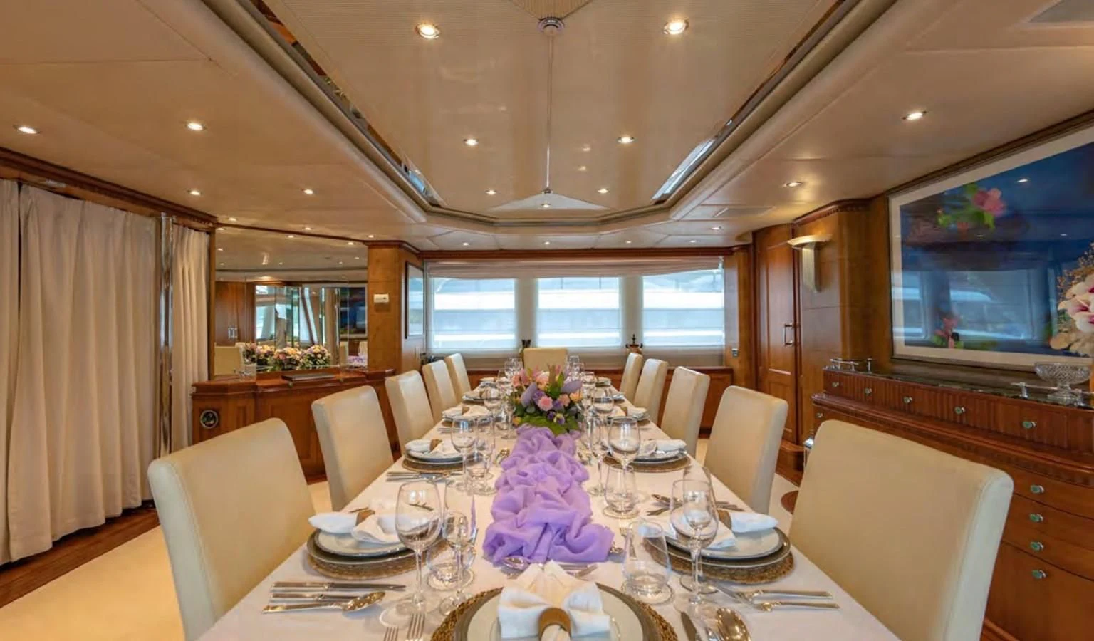 a dining room with a table set for a formal dinner aboard AZUL V Yacht for Charter