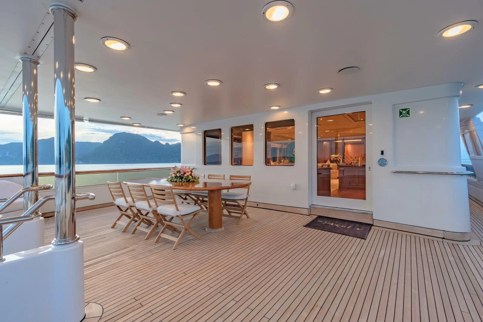 a large room with a table and chairs and a large window aboard AZUL V Yacht for Charter