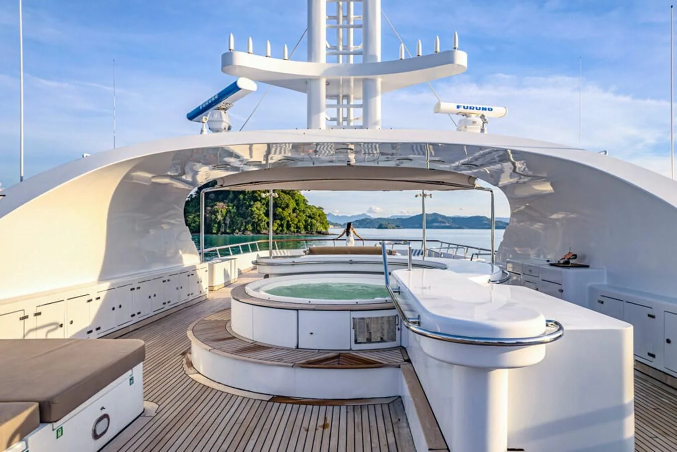 a deck with a pool and a large ship in the background aboard AZUL V Yacht for Charter