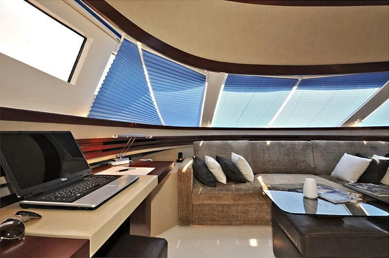 a laptop on a table in a room with a couch and a window aboard M.T. TIME Yacht for Sale