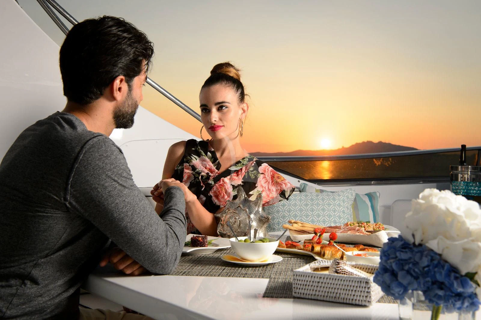 a man and woman sitting at a table with food aboard AMAYA Yacht for Sale