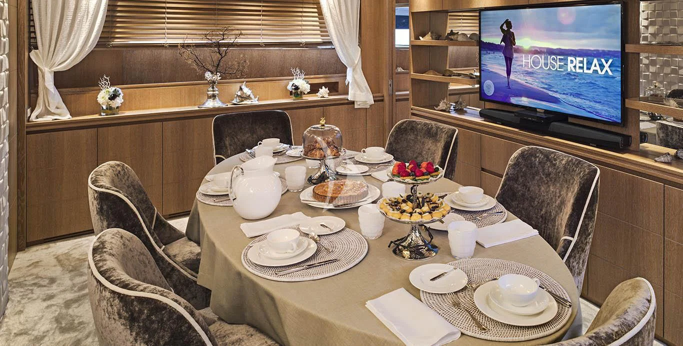 a table with plates and cups on it aboard AMAYA Yacht for Sale