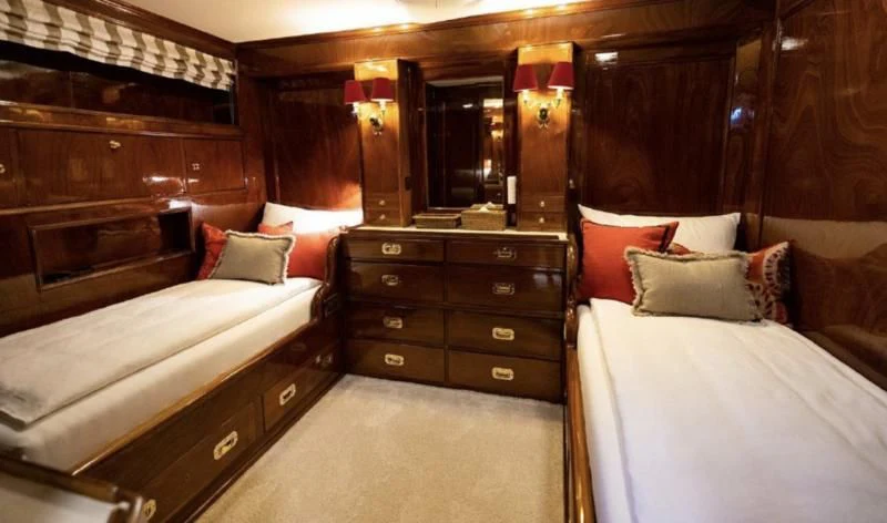 a room with a bed and a dresser aboard FRANCESCO PETRARCA Yacht for Sale