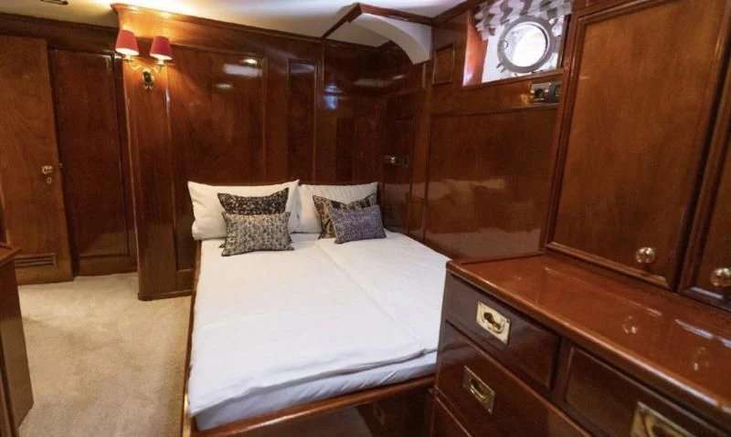 a room with a bed and a dresser aboard FRANCESCO PETRARCA Yacht for Sale
