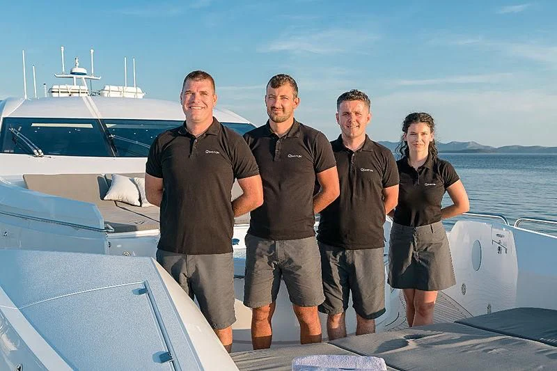 a group of people posing for a photo on a boat aboard QUANTUM Yacht for Sale