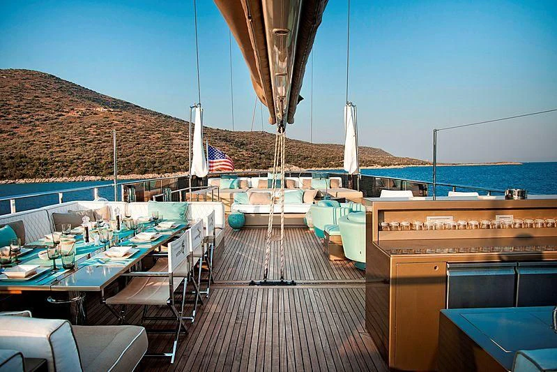 a deck with tables and chairs aboard MERMAID Yacht for Sale