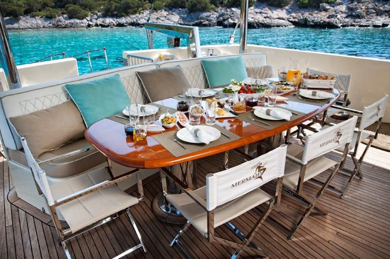 a table with chairs and food on it aboard MERMAID Yacht for Sale