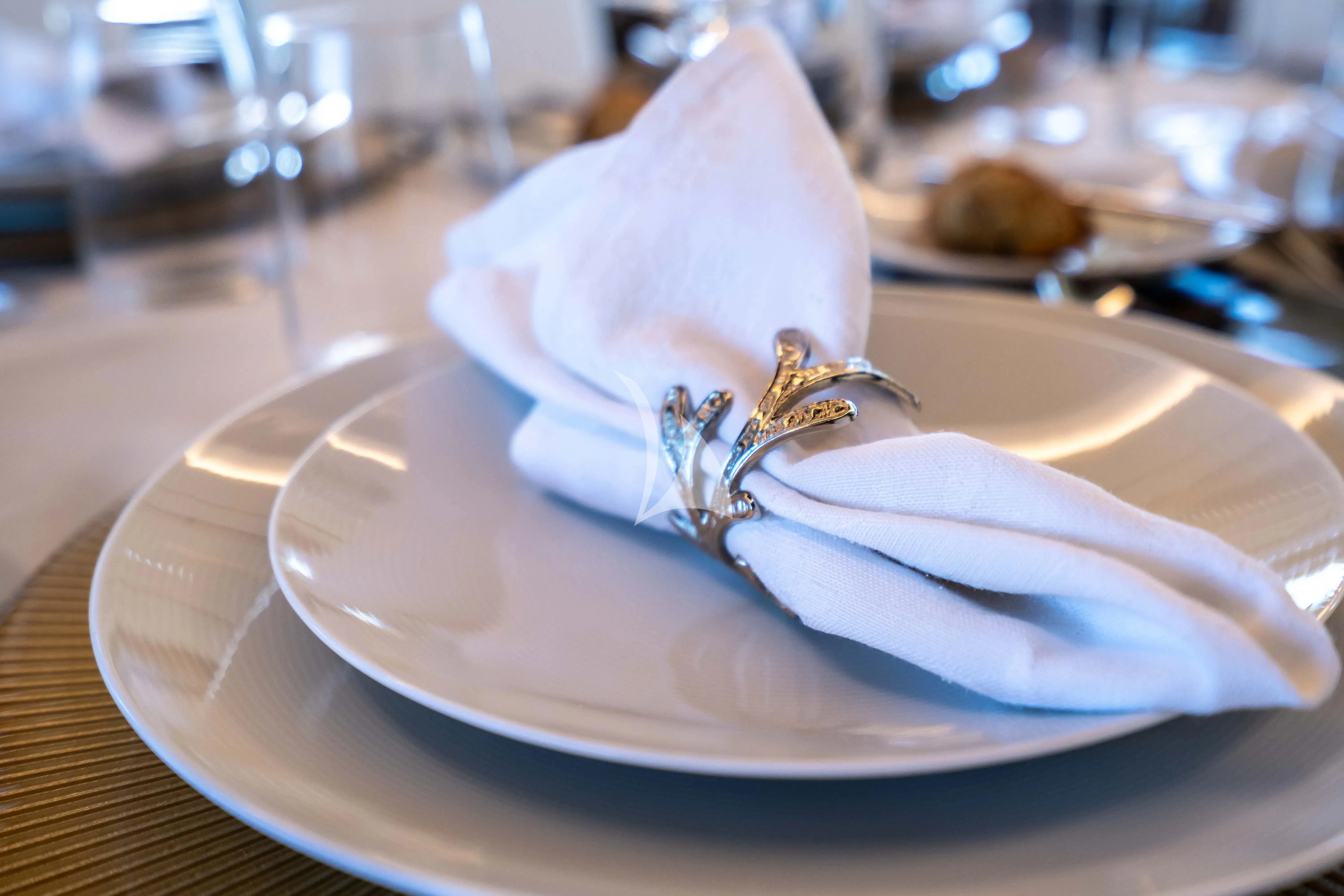 a white napkin with a gold ring on it aboard KOUKLES Yacht for Sale