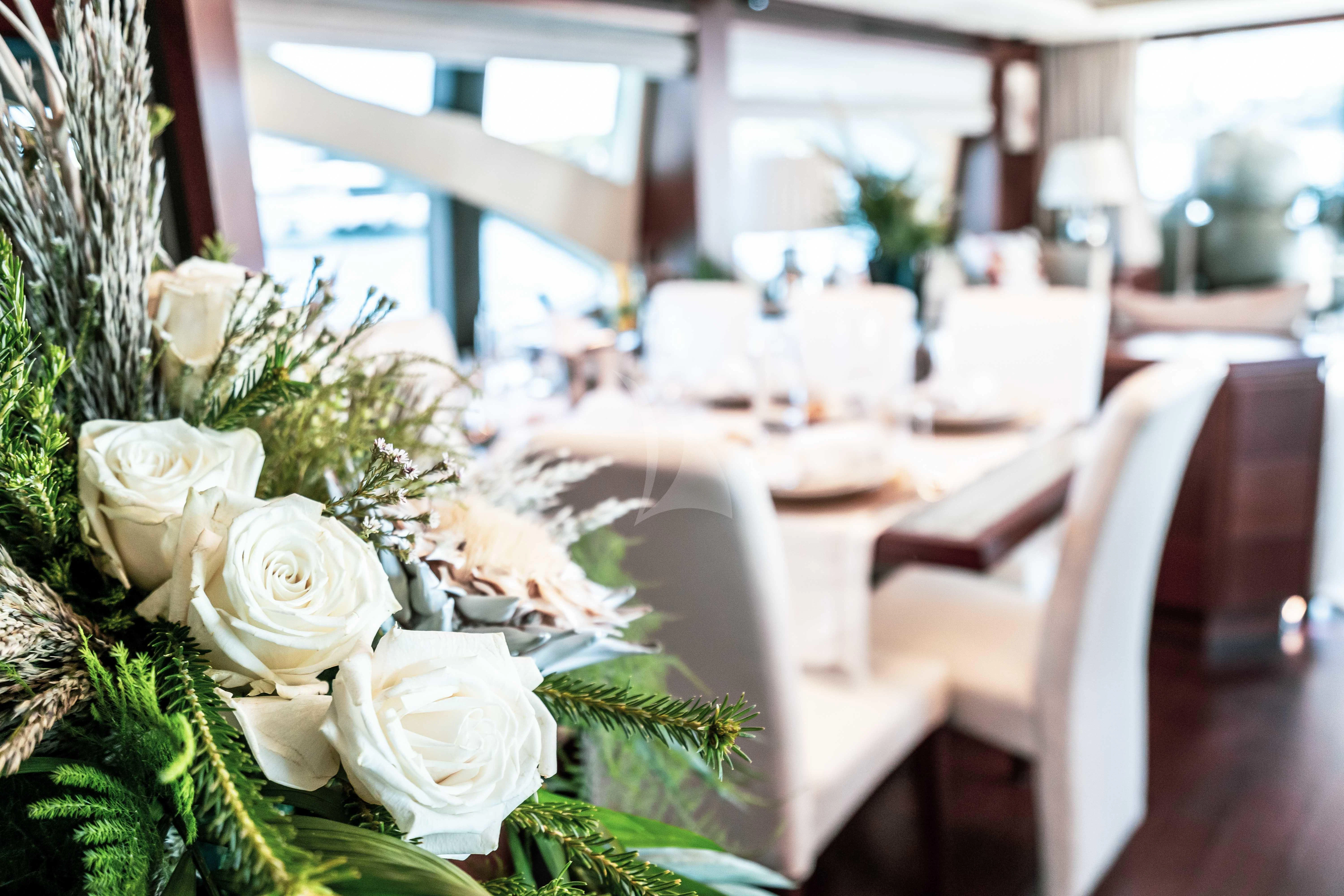 a group of white roses on a table aboard KOUKLES Yacht for Sale