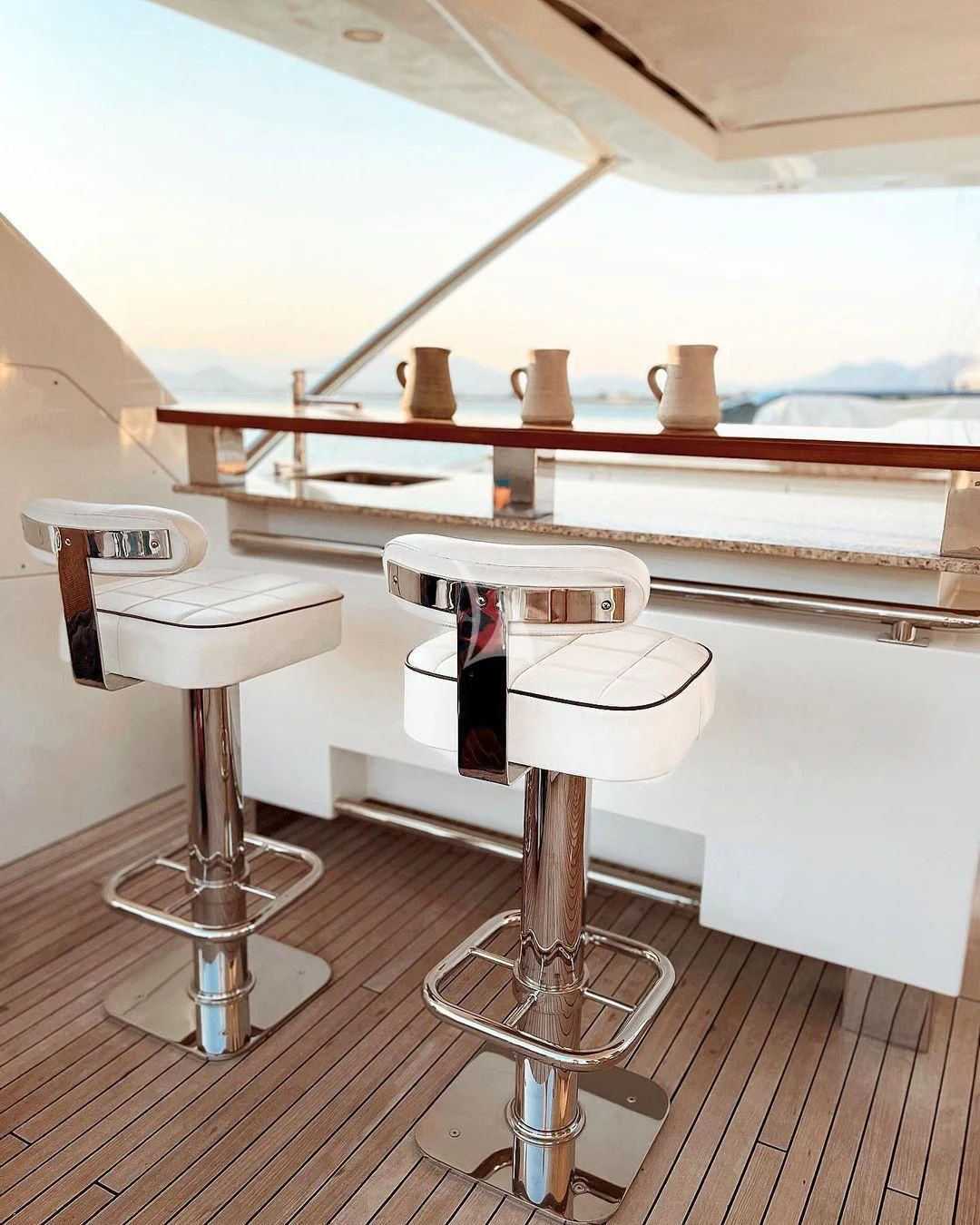 a table with stools and a window aboard KOUKLES Yacht for Sale