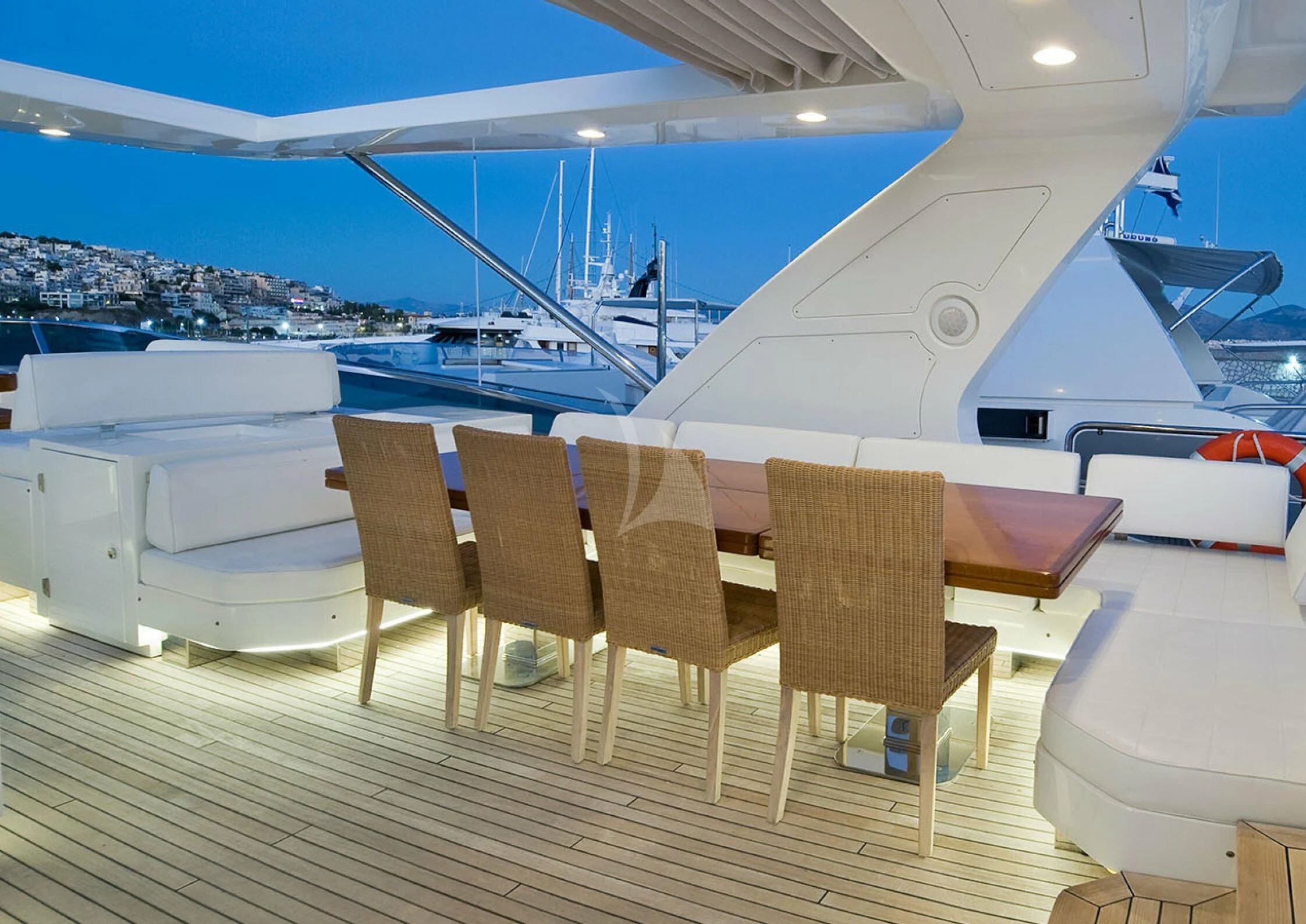 a deck with chairs and a boat in the water aboard KOUKLES Yacht for Sale